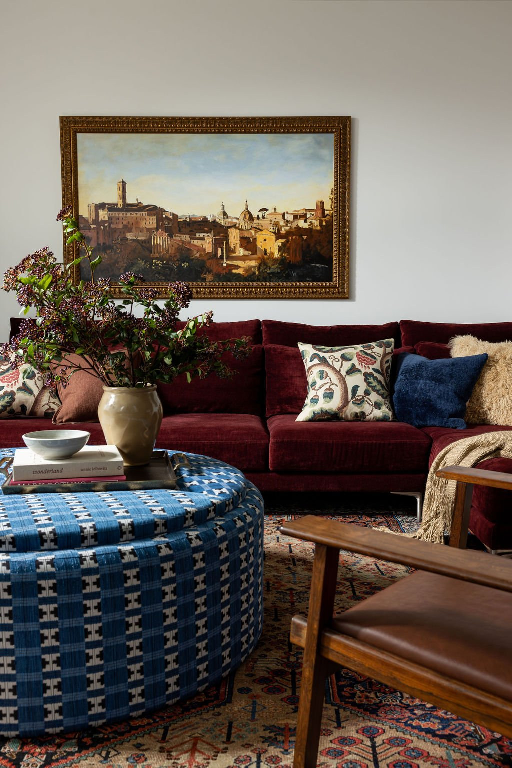 Alvarado living room with a deep red velvet sofa, blue patterned ottoman, and framed art, a Studio Nauleau home in Noe Valley, San Francisco