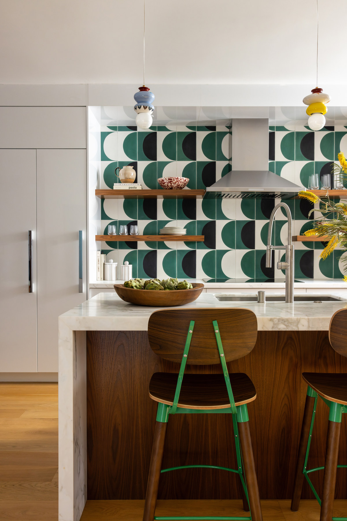 Studio Nauleau kitchen with green patterned tile, a marble island, and woven bar stools